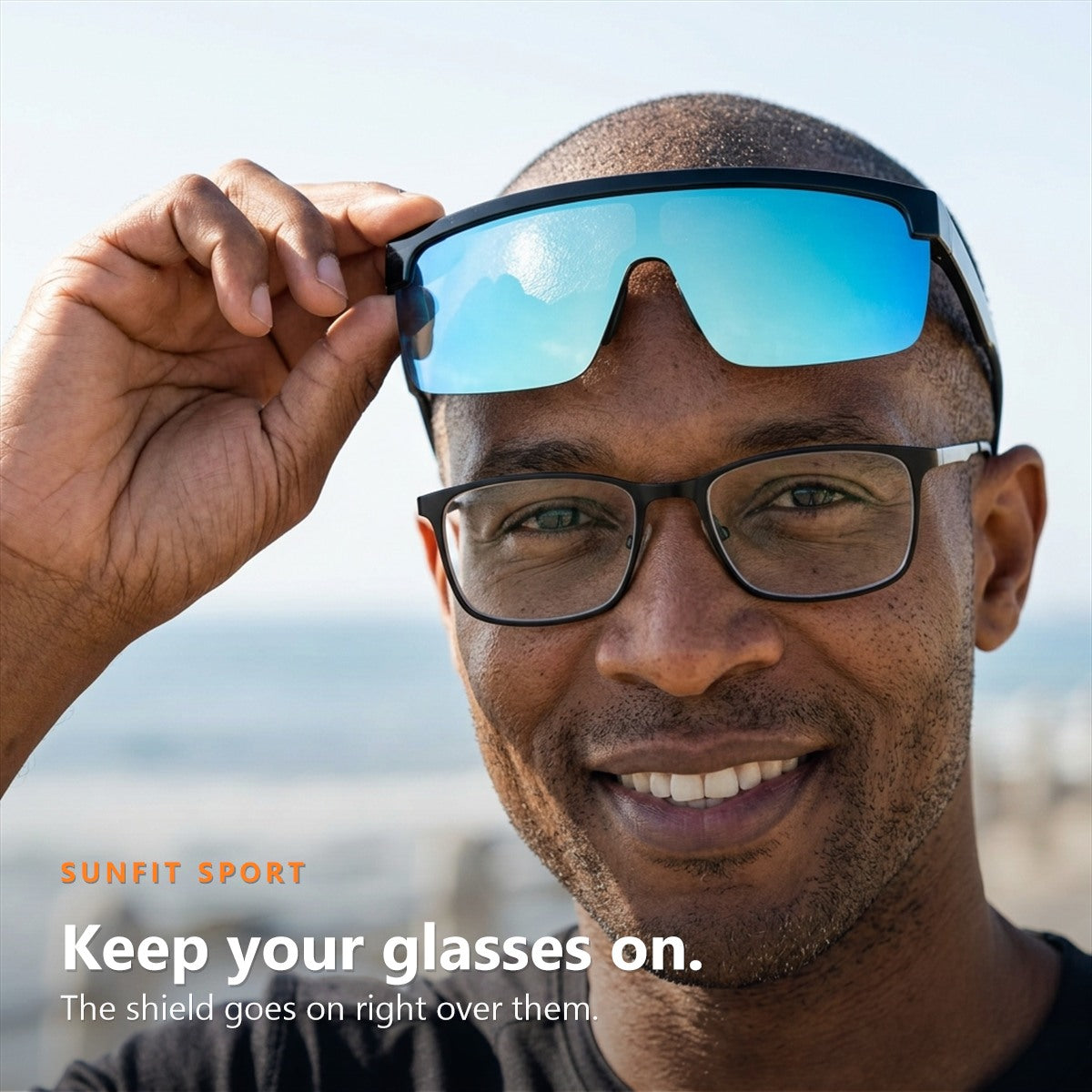Man lifting SunFit Sport onto his forehead with his right hand, his own prescription glasses still on his nose: keep your glasses on